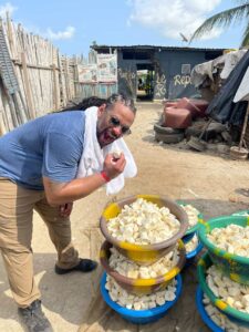 Traveler tasting freshly cut cassava at a local market in Abidjan